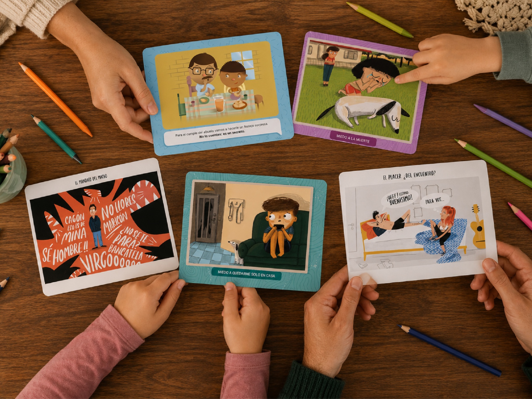 Manos jugando con las tarjetas ilustradas de Colectiva Lúdica